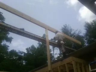 Carpenter setting a ridge beam over a new addition frame — Ice Dam Removal by Roofing Brothers in Dufur