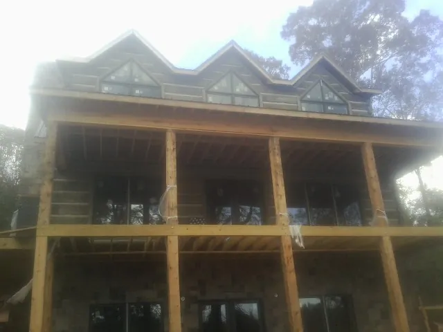 Dormers and porch framing on a large log home under construction — Roof Coating work by our crew in Dufur