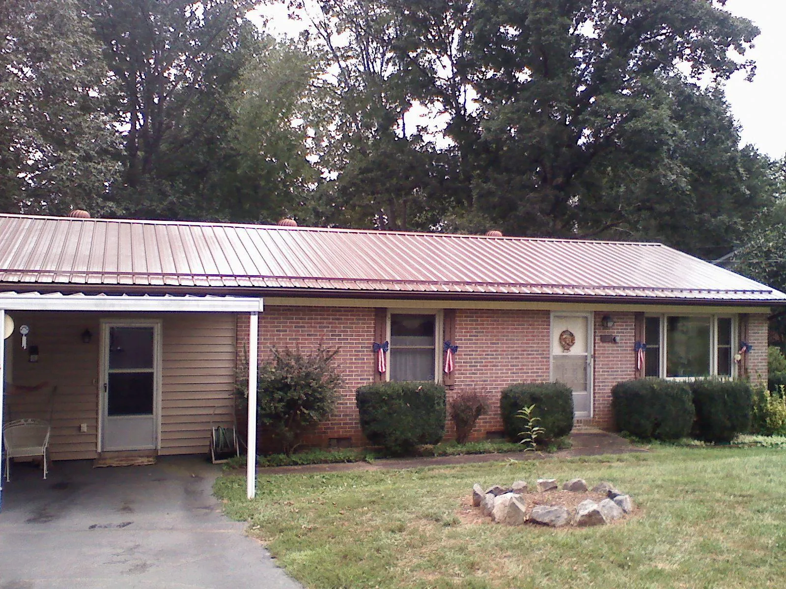 Bronze metal roof and carport on a brick ranch home — Roof Repair work by our crew in Dufur